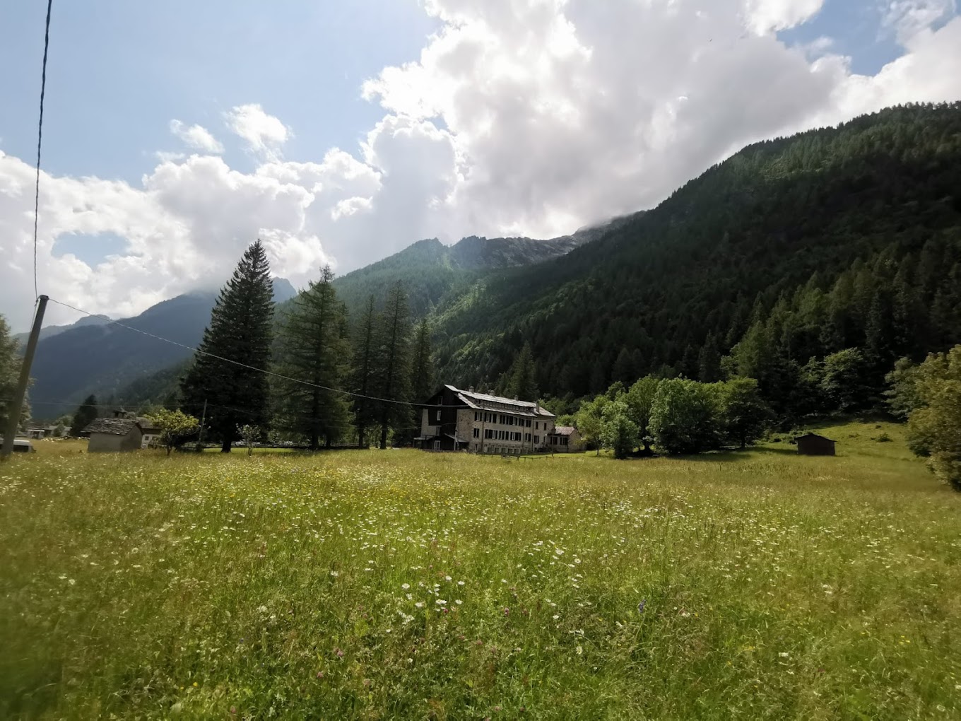 Facciata esterna della casa per ferie soggiorno alpino a macugnaga, circondata da una grandissima area verde.